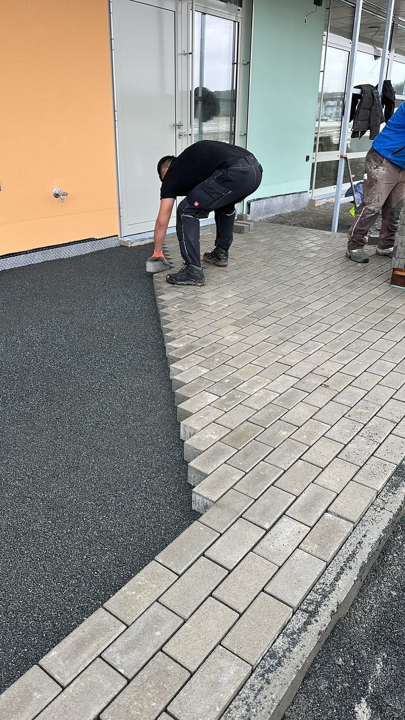 Pflaster mit Anschluss an einen Fallschutzbelag